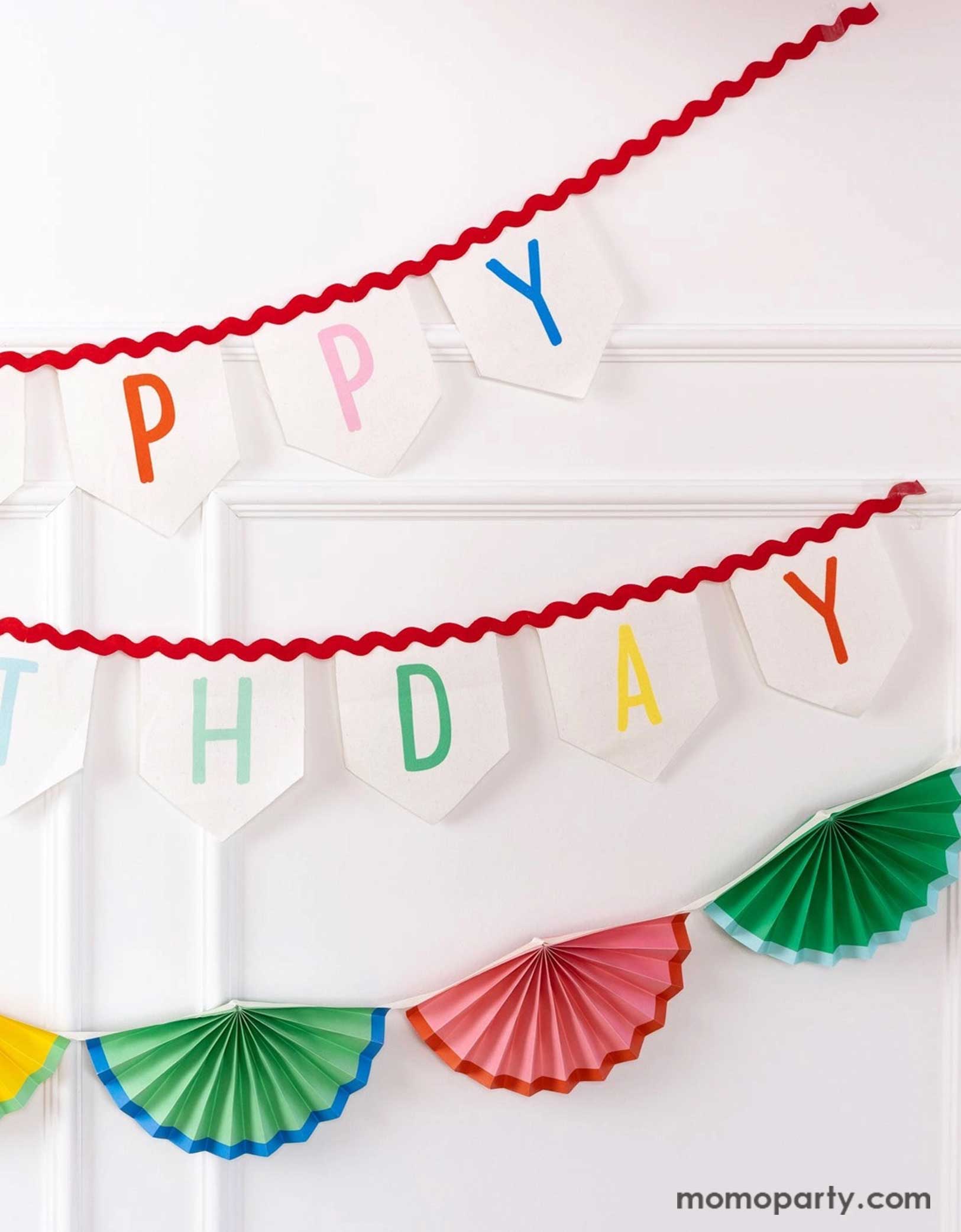 A white wall decorated with Momopartys's 6' Happy Birthday Felt Banner & colorful bunting garland by My Mind's Eye. Celebrate in style with these amazing Happy Birthday decorations! These banners will elevate any party with its vibrant design and premium felt material. Perfect for any birthday celebration, these cheerful decorations will bring joy and excitement to any special occasion. Check out momopartys.shop for more birthday party supplies now!