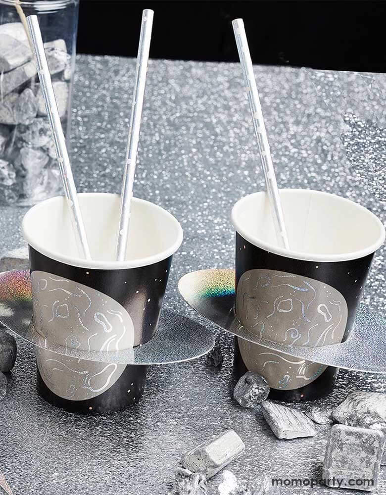 A party table dressed in silver foil tablecover with some space rock decorations on the table, along with two of Momopartys's 9" planet party cups by Hooty Ballloo topped with silver foil straws, makes this a great decorating idea for kid's space themed party, be it a "Two the Moon" 2nd birthday party or a "First Trip around the Sun" first birthday party.