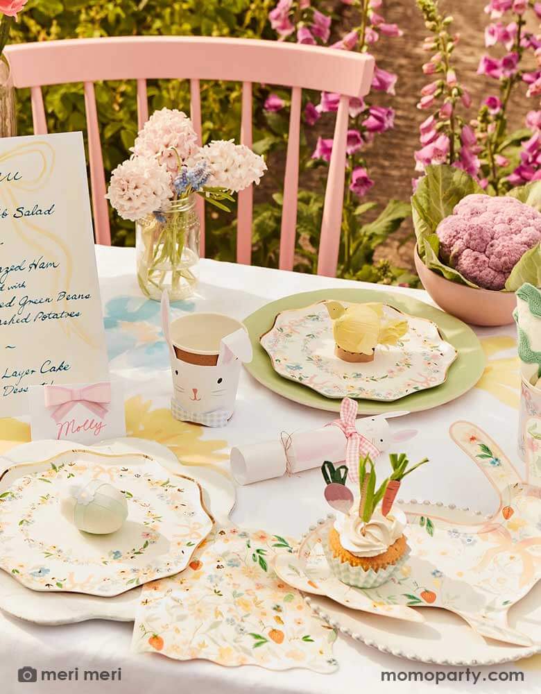 A spring Easter themed party table featuring Momopartys's Elegant Floral Party Collection including dinner plates, side plates, napkins and bunny shaped plates, on the table there are spring flowers, Easter inspired cupcakes, bunny shaped party cups and bunny shaped party crackers, makes this a perfect inspo for an elegant Easter celebration.