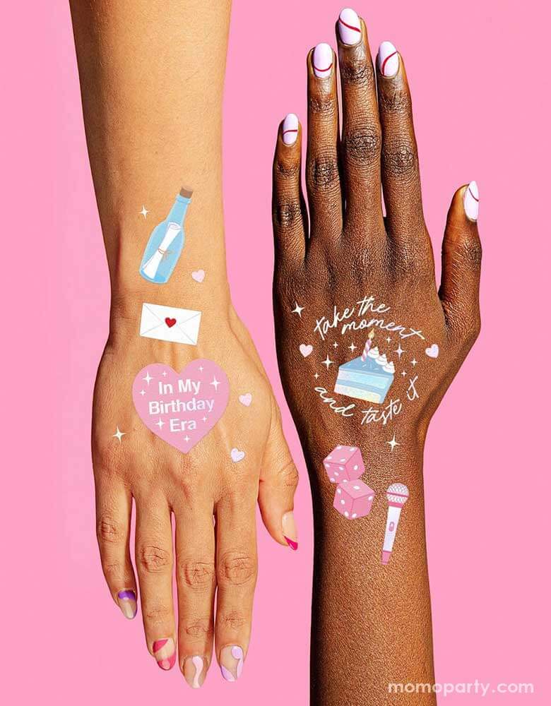 Two hands with Momopartys Birthday Taylor Swift Era Temporary Tattoos by Xo, Fetti. Featuring Taylor Swift inspired designs including  the iconic Taylor Swift-themed designs including snakes, butterflies, red lipsticks and more. They're perfect for girl's Taylor Swift themed birthday party activities.