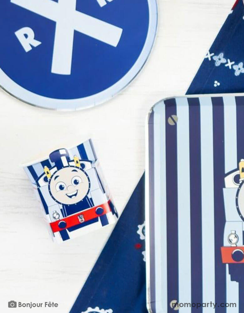 A kid's train themed birthday party table with Momopartys's Thomas and Friends party supplies including the 3D party cups, train railroad round blue side plates, and Thomas & Friends blue striped dinner plates. A perfect combination for your toddler's choo choo train themed celebration!