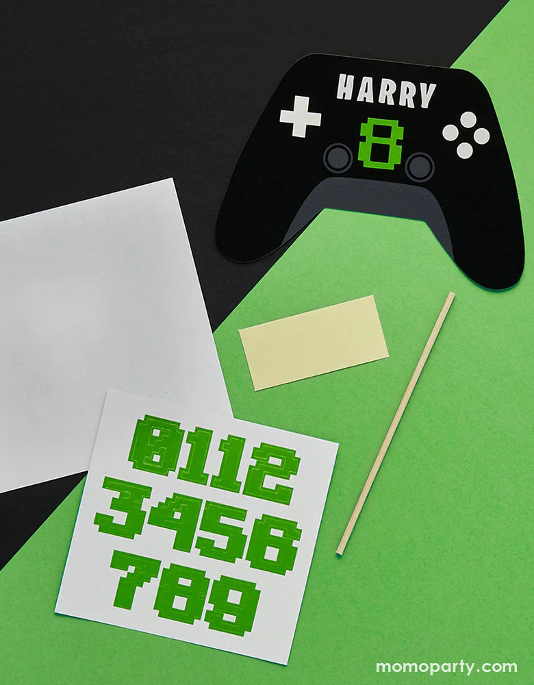 Momo Party's Video Game Console Controller shaped personalized Cake Topper by Hooty Balloo. Come with two sticker sheets, you can customize this cake topper with the birthday person's name and age. In a classic black and green colors, it's perfect for kid's video game themed birthday party. 