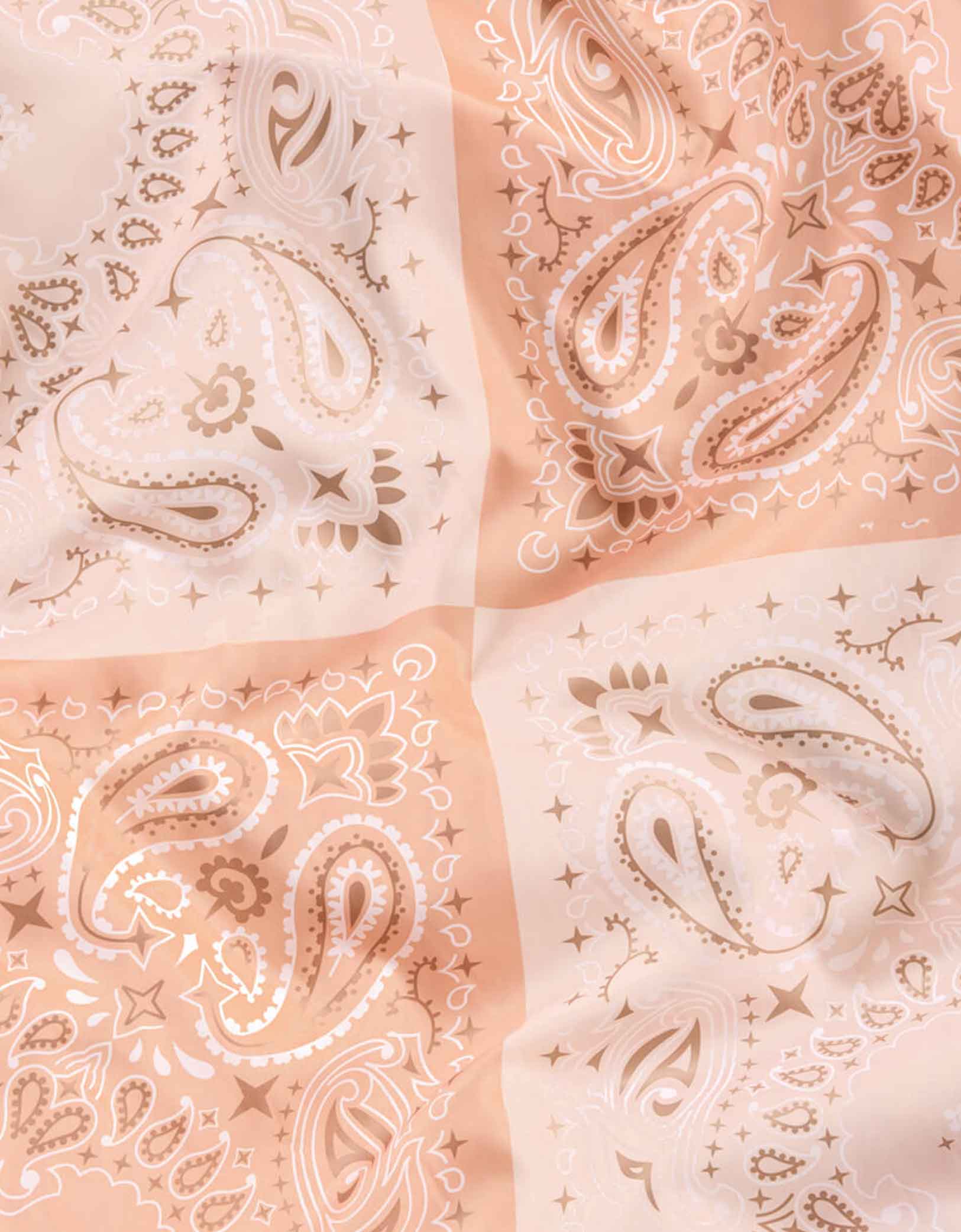 A close up look at Momopartys's 9' x 4' Wild Wild West Washable Tablecloth by Xo, Fetti. With peach shade bandana design, this table cover is made with 100% machine wash friendly polyester. It's perfect for a western themed celebration for all cowboys and cowgirls! This tablecloth is guaranteed to get the party as wild as the wild wild west! Saddle your horse and invite all of your rodeo partners because this party is about to get wild!