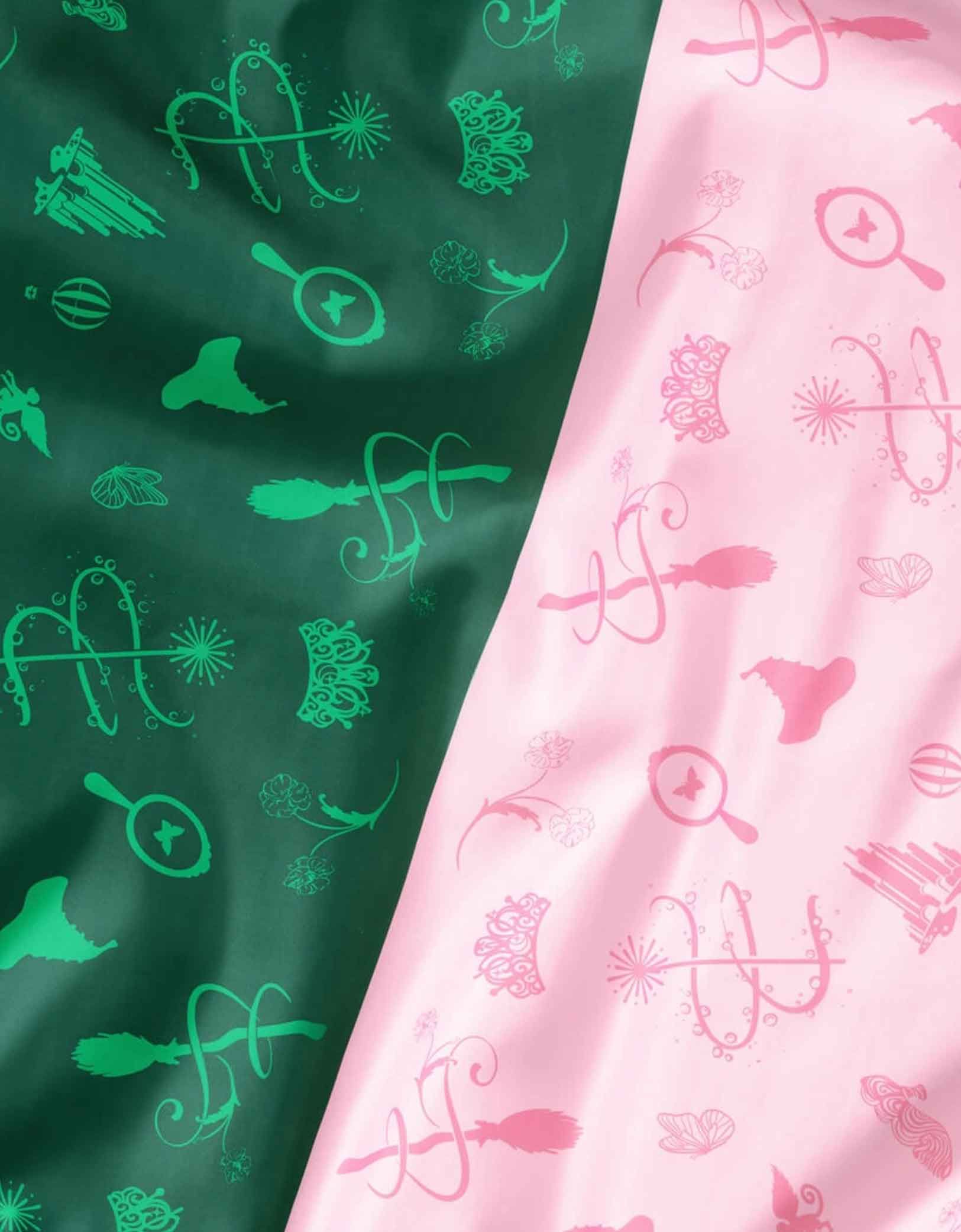 A close up of Momopartys's two patterned Wicked party tablecloth, one green with Wicked themed patterns and the other pink.