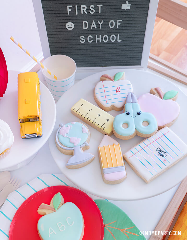  Momopartys - Morden Back To School Party Table Ideas with Back to school themed cookies, Oh happy day Cherry Red side plate, Aqua Striped Large Plates and cups, Leaf Napkins, Letter board with "First Day of School" sign, cupcakes, and school bus toy on cake stand as tableware