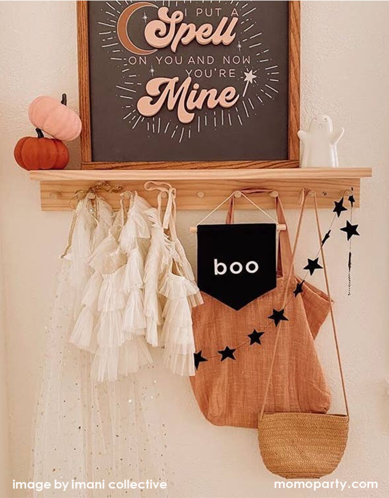 Kid's room wall shelf hanging with girl's beautiful tutu dresses, a black canvas Boo hang Sign, black star banner, Woven bags. And felt pumpkins, a wooden framed poster with "i put a spell on you and now you're Mine" words. a cute white ghost figures. These modern unique halloween product are so fun for your little one's room decoration, party decoration, and instagram worthy photos for you halloween celebration memories. Sell from Party Boutique Online at momopartys.shop