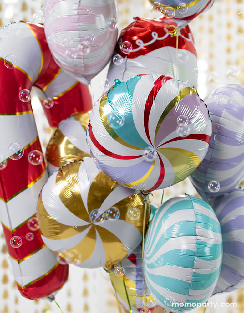 Holiday Foil balloons boutique with Candy Foil Balloon in Mixed Colors, Pastel purple color, Pink color and green color, Red Candy Cane Foil Mylar Balloon and Santa foil balloon. in front of Christmas Tree Gold Backdrop, with lots of bubbles around, Such a fun party decoration for a holiday celebration