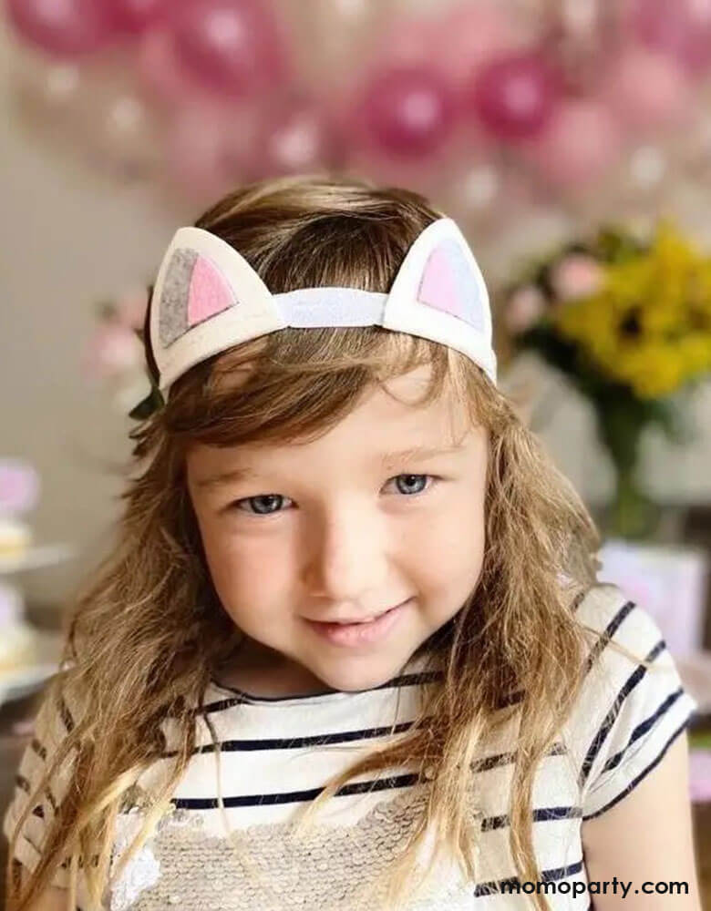 A girl dressed up in Momopartys's felt cat headband in a cat themed birthday party