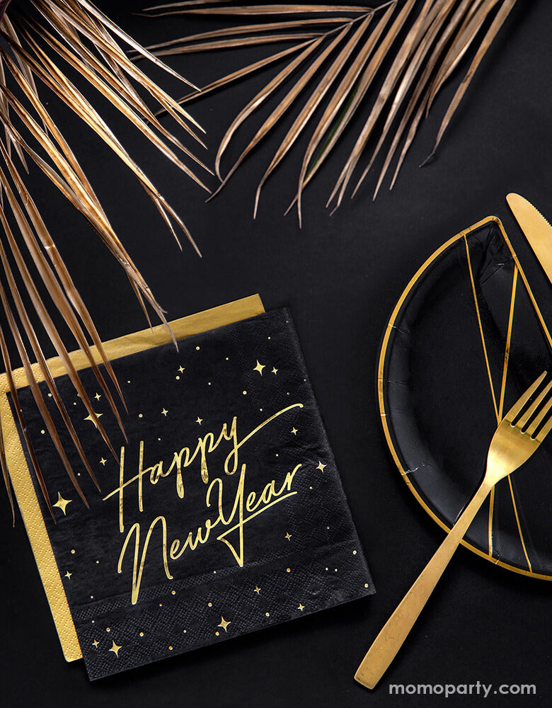 Black and gold new year party table set up with Party Deco - Happy New Year Large Napkins layered with gold napkin, black and gold foil special shaped party plates with gold folk, Floral as centerpiece in a black table top. Ring in the New Year in style with this gorgeous Happy New Year party collection with gold foil detail. This black and gold new year collection is the perfect party tableware for a new year party! 