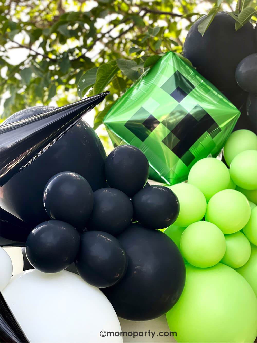 Minecraft themed Birthday Party Ideas by Momopartys. Close up look of modern party Backdrop with minecraft themed color balloons in green, black, white, and creeper foil balloon, black starburst foil balloon.