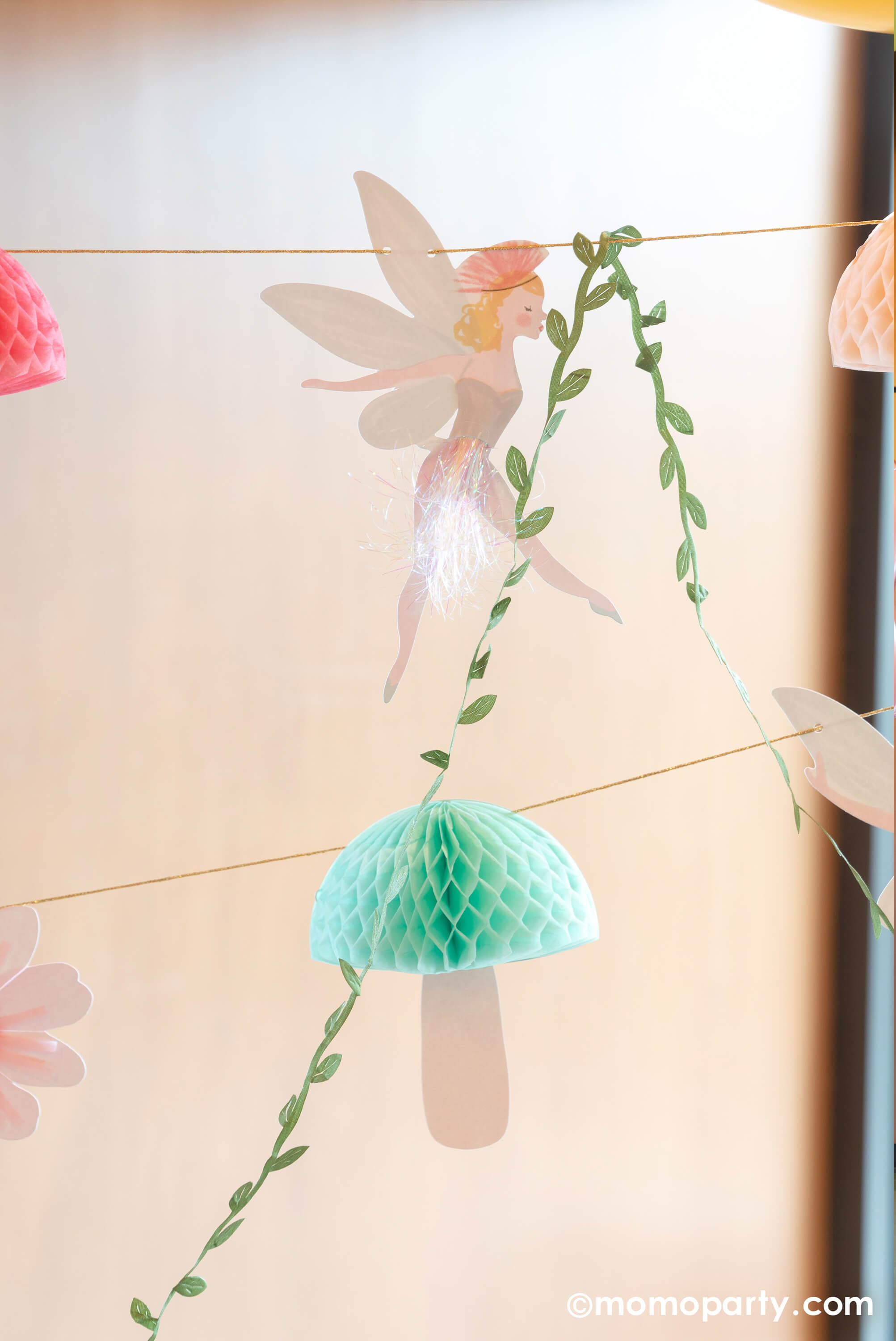 A close up to Momopartys's 10ft fairy garland. This beautiful garland will make a fairy or princess party look extra special. It features fairies, flowers, leaves and funghi, with lots of gorgeous embellishments. 