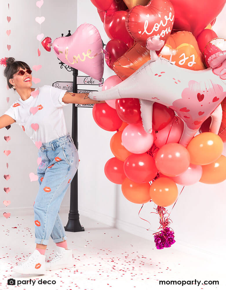 A girl holding a bouquet of Momopartys's red and pink heart-shaped balloons, celebrating Valentine's Day.