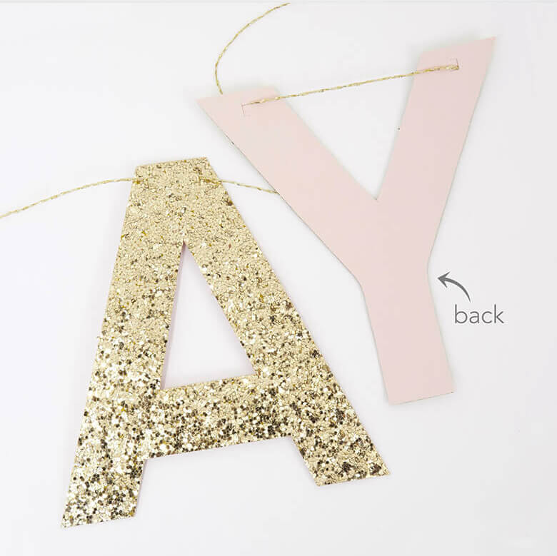 front and back details of Meri Meri Pink Happy Birthday Fringe Garland. The Eco-friendly glittered letters are pre-threaded onto cord, and back in a peach color