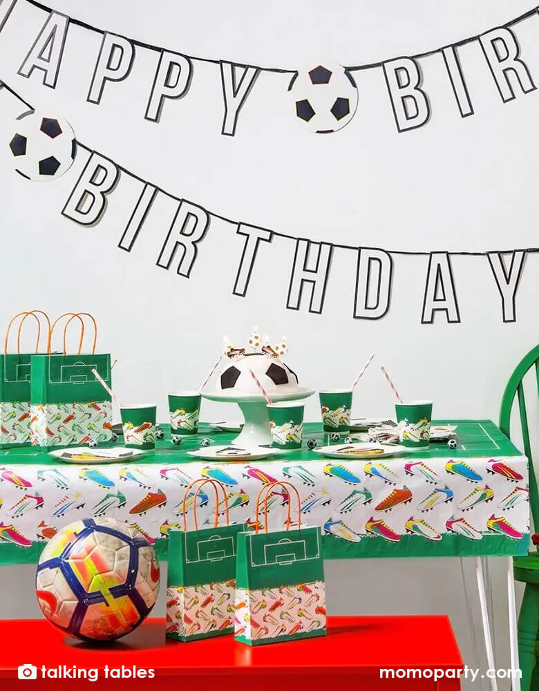 A soccer themed birthday party table filled with soccer themed party cups, plates, and party favor bags, along with Momopartys's Happy Birthday garland by Talking Tables is perfect for celebrating soccer fans. With black and white lettering, set off by the touch of bright color in the soccer cleats, this soccer birthday decoration can be paired with our matching napkins and plates or those of your favorite teams.