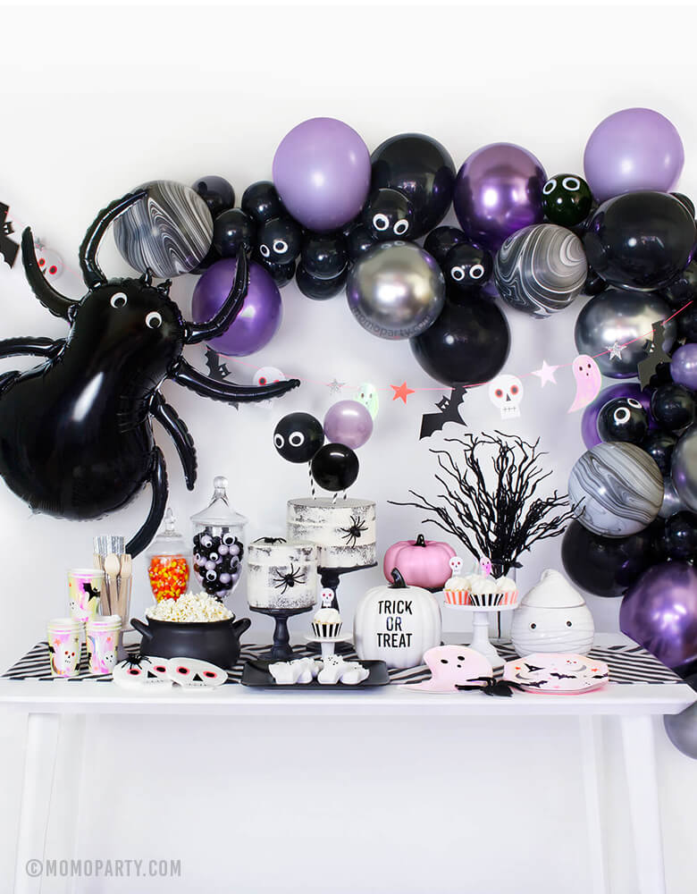 Momopartys Modern Halloween party in a box, party look with balloon garland, Meri Meri Spider Foil Mylar Balloon, halloween icon garland, table set up with MeriMeri Iridescent Ghost Plates, Halloween Icons Side Plates and cups, skull napkin, naked cake with spiders, googly eyes with gum balls in a jar, pink pumpkin decor, white pumpkin with "Trick or Treat", black witch pot with popcorns, party inspiration for for halloween party, trick-or-treat Halloween party, Haunted House Birthday Party, Witch Party